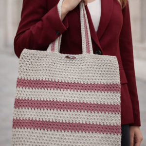 Frau trägt handgehäkelte Shopper Tasche in Natur und Bordeaux zu einem bordeauxfarbenen Blazer